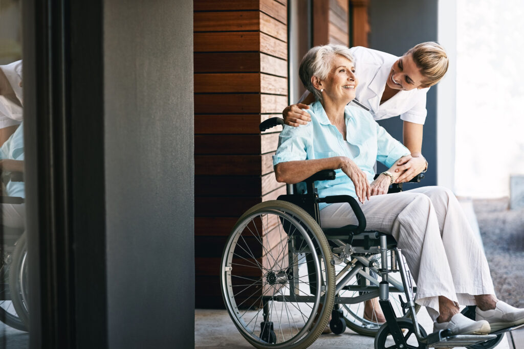 Caregiver assisting a smiling senior in a cozy Aberdeen, NC home, highlighting in-home support services.