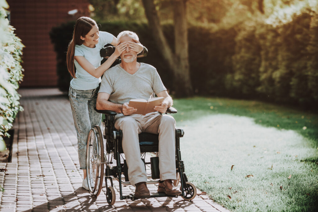 Caregiver assisting a smiling senior in a cozy Aberdeen, NC home, highlighting in-home support services.